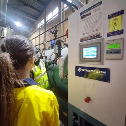 Trainees operating a boiler control panel on site